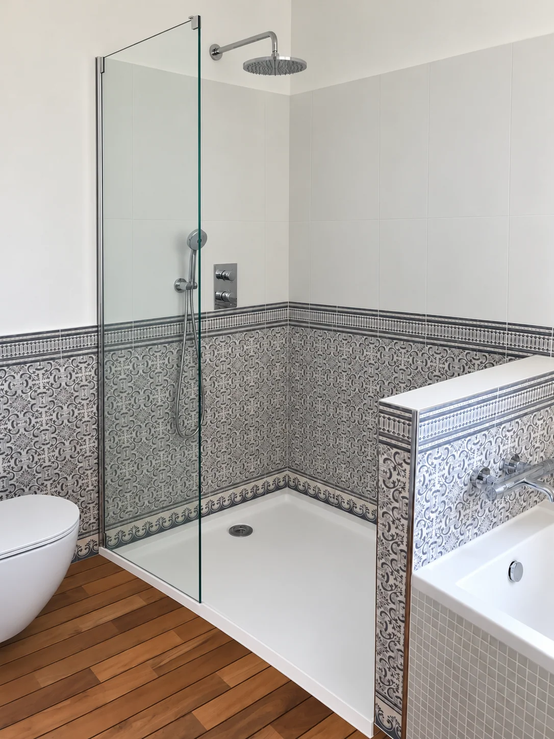 Douche vitrée avec receveur blanc, carrelage à motifs bleus et robinetterie chromée.