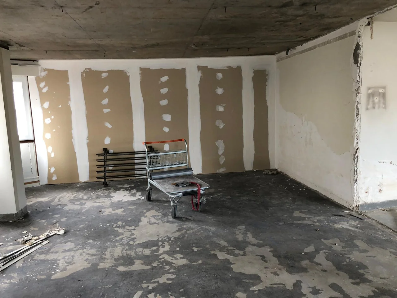 Pièce pendant les travaux avec reprises d’enduit sur les murs et sol brut.