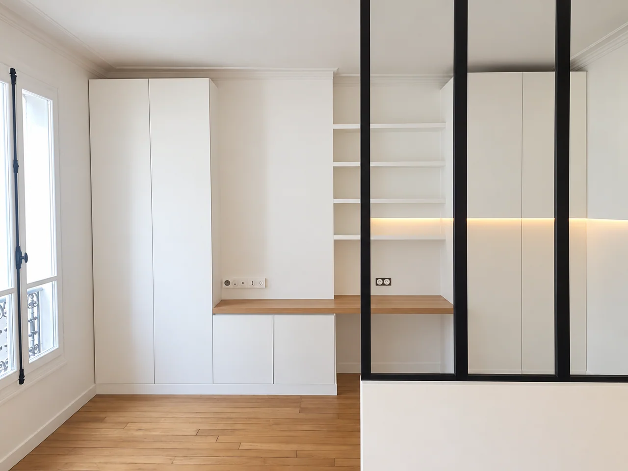 Bureau avec rangements blancs, plan aspect bois et verrière noire au premier plan.